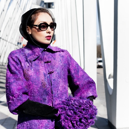 Stylish lady in bright purple coat in a cityの写真素材