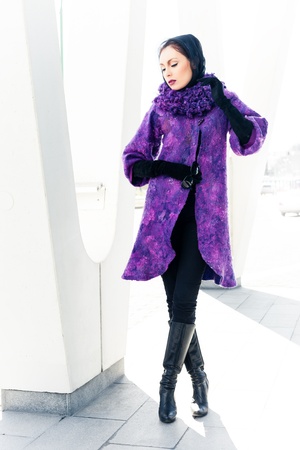 Stylish lady in bright purple coat in a cityの写真素材