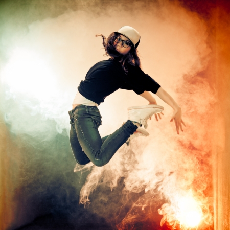 Teenage brakedancer girl jumping in a smokeの写真素材