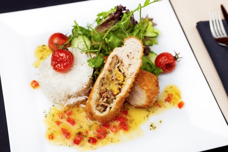 Stuffed chicken fillet with cheese trio, kumquat sauce and nutty riceの写真素材