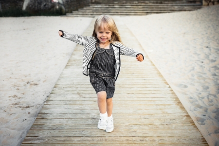 Happy little girl running on a beachの写真素材