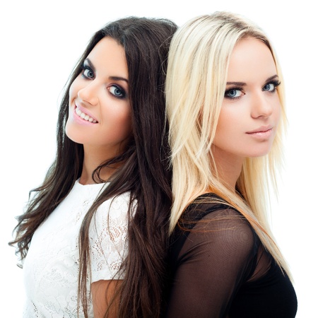 Two happy girlfriends posing on white backgroundの写真素材