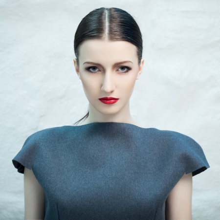 Fashion portrait of beautiful female model covered with blue lightの写真素材