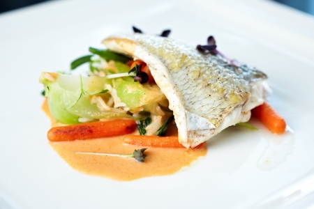 Fried whitefish fillet stir-fried with green vegetables, jasmine rice, carrot salad and a creamy shrimp sauceの写真素材