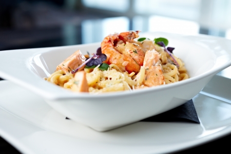 Creamy seafood pasta with salmon, shrimp, mussels and Grana Padano cheeseの写真素材
