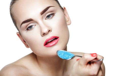 Portrait of a young woman eating eyeshadows on white backgroundの写真素材