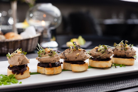 Homemade duck liver patee with cedar nuts, dried plums, bruschetta and red onion jamの写真素材