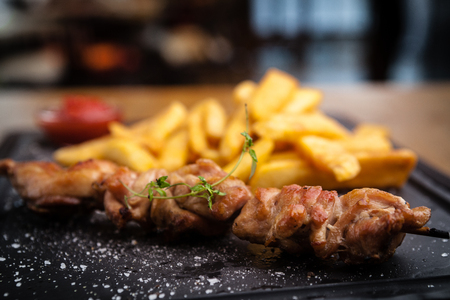 Barbecue grilled pork shashlik kebabs served with french friesの写真素材