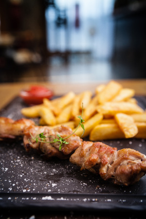 Barbecue grilled pork shashlik kebabs served with french friesの写真素材