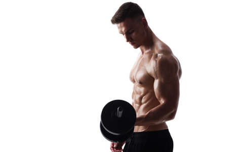 Athletic shirtless young male fitness model makes exercises with dumbbells on white backgroundの写真素材