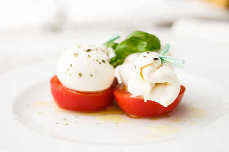 Mozarella cheese with tomatoes and basil in olive oil dressingの写真素材