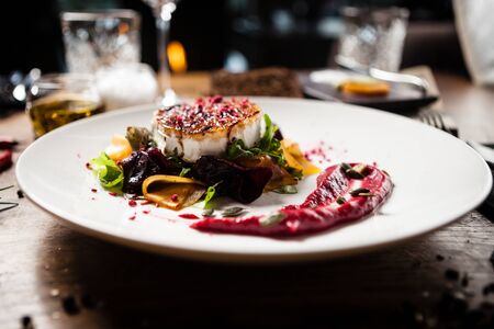 Grilled goat cheese salad served on a plate in restaurantの写真素材