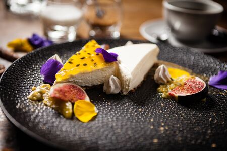 Cheesecake with passionfruit served on a plate in restaurantの写真素材
