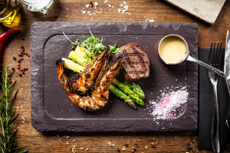 Tasting menu. Beef steak and grilled tiger prawns with asparagus and garlic sauce