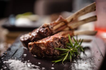 Grilled lamb chops served with a branch of rosemaryの写真素材
