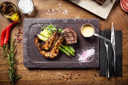 Tasting menu. Beef steak and grilled tiger prawns with asparagus and garlic sauceの写真素材