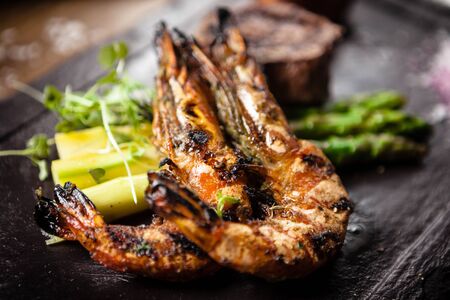 Tasting menu. Beef steak and grilled tiger prawns with asparagus and garlic sauceの写真素材