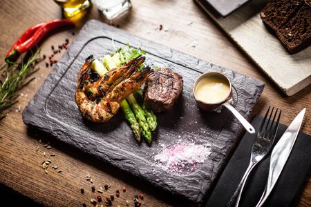 Tasting menu. Beef steak and grilled tiger prawns with asparagus and garlic sauceの写真素材