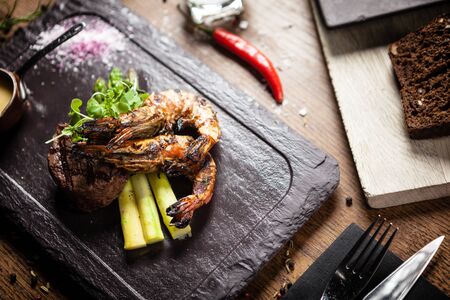 Tasting menu. Beef steak and grilled tiger prawns with asparagus and garlic sauceの写真素材