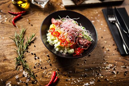 Poke with beef served in a black bowl in restaurantの写真素材