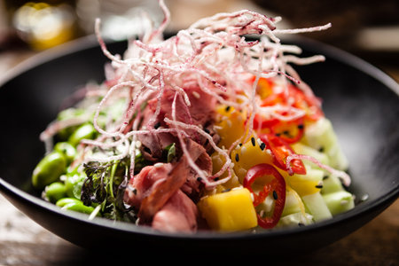 Poke with beef served in a black bowl in restaurant