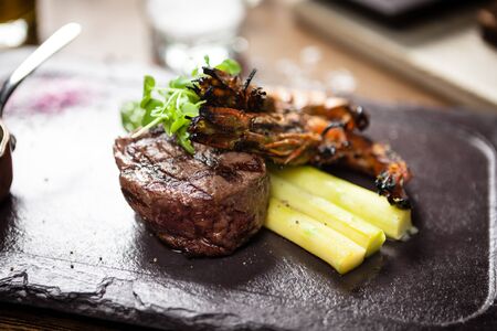 Tasting menu. Beef steak and grilled tiger prawns with asparagus and garlic sauceの写真素材