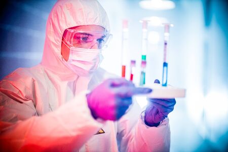 corona virus concept. male doctor reviewing test-tubesの写真素材
