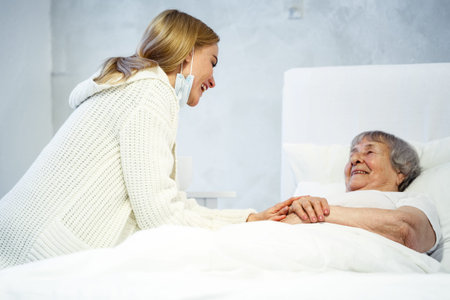healthcare in hospital concept. daughter visiting old lady in hospital