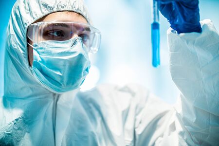 corona virus concept. male doctor reviewing test-tubeの写真素材
