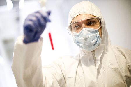 corona virus concept. male doctor reviewing test-tubeの写真素材