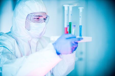 corona virus concept. male doctor reviewing test-tubesの写真素材