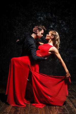 young couple in elegant evening dresses dancingの写真素材