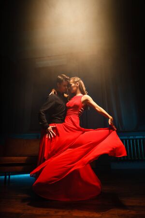 young couple in elegant evening dresses dancingの写真素材