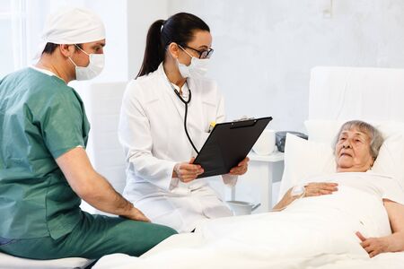 healthcare in hospital concept. two doctors making medical examination of old ladyの写真素材