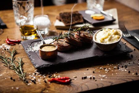 Pork tenderloin served on a board in restaurantの写真素材