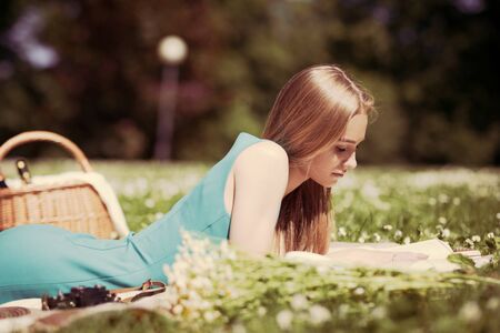 Portrait of happy young woman having rest on picnic in parkの写真素材