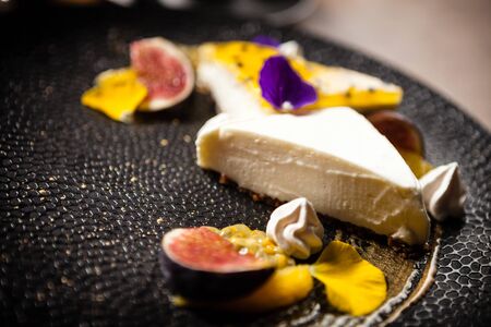 Cheesecake with passionfruit served on a plate in restaurantの写真素材