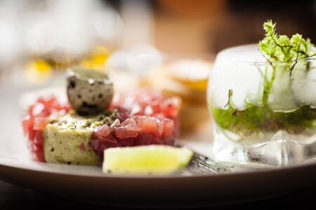 Tuna tartare: Guacamole quail egg baguette on a plate. Delicious healthy raw food closeup served for lunch on a table in modern gourmet cuisine restaurant.の写真素材