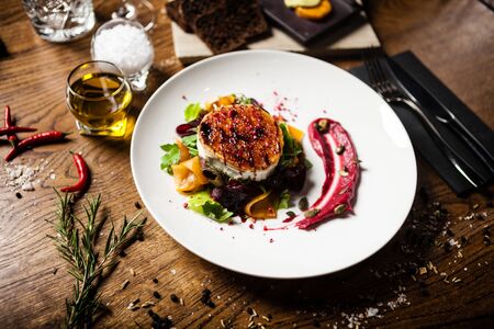Grilled goat cheese salad Pickled beetroot pumkin, cranberry jam, pumkin seeds Delicious healthy mediterranean traditional vegeterian food closeup served for lunch in modern cuisine gourmet restaurantの写真素材