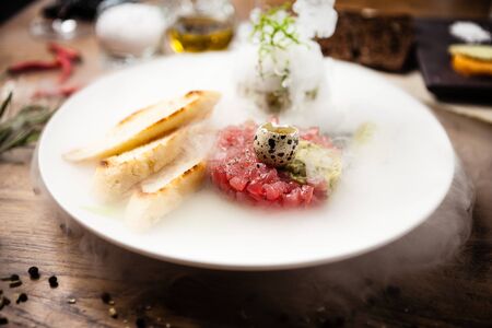 Tuna tartare: Guacamole quail egg baguette on a plate. Delicious healthy raw food closeup served for lunch on a table in modern gourmet cuisine restaurantの写真素材