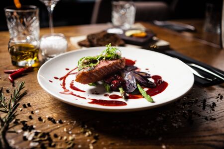 Duck breast with asparagus, salad and sauce on white plate. Delicious healthy grilled and roasted bird fillet food closeup served on a table for lunch in modern cuisine gourmet restaurant.の写真素材