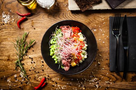 Poke with beef: Glass noodle, avocado, edamame and mango in a bowl. Delicious healthy food closeup served for lunch on a table in modern gourmet cuisine restaurant.の写真素材