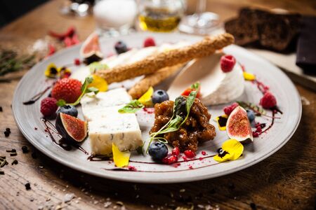 Cheese platter for two: Goat cheese cream, gorgonzola, camembert, grissini and fig jam. Delicious healthy Italian traditional food closeup served for lunch in modern gourmet cuisine restaurantの写真素材