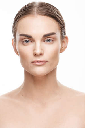 Natural beauty and skincare concept. Portrait of beautiful female model with clean face isolated on white background. Young woman shows healthy sensitive skin after using cosmetics and makeupの写真素材