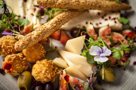 Cheese platter for two: Goat cheese cream, gorgonzola, camembert, grissini and fig jam. Delicious healthy Italian traditional food closeup served for lunch in modern gourmet cuisine restaurantの写真素材