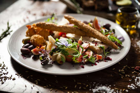 Cheese platter for two: Goat cheese cream, gorgonzola, camembert, grissini and fig jam. Delicious healthy Italian traditional food closeup served for lunch in modern gourmet cuisine restaurantの写真素材