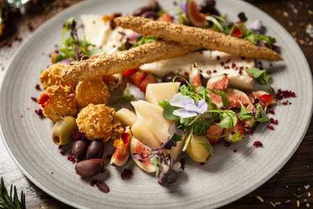 Cheese platter for two: Goat cheese cream, gorgonzola, camembert, grissini and fig jam. Delicious healthy Italian traditional food closeup served for lunch in modern gourmet cuisine restaurantの写真素材