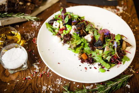 Fresh vegan salad. Avocado, couscous, melon, portobello, soybean, tofu on white plate. Delicious healthy mixed greens food closeup served on a table for lunch in modern cuisine gourmet restaurant.の写真素材