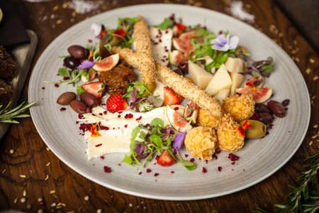 Cheese platter for two: Goat cheese cream, gorgonzola, camembert, grissini and fig jam. Delicious healthy Italian traditional food closeup served for lunch in modern gourmet cuisine restaurantの写真素材