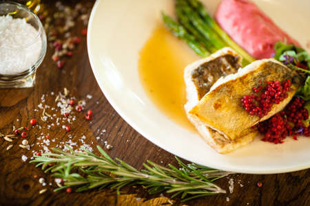 Pike-perch fillet. Asparagus, pearl couscous, white wine sauce, beet-flavored mashed potatoes. Delicious seafood fish closeup served on a table for lunch in modern cuisine gourmet restaurantの写真素材